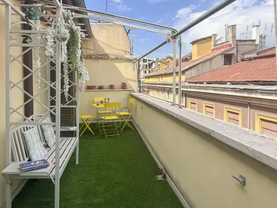 a balcony with green grass and a table and chairs at Vatican Attic With Terrace in Rome