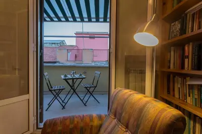 a living room with a couch and a view of a patio at Vatican Attic With Terrace in Rome