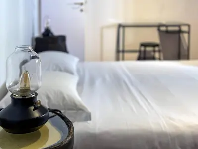 a glass jar on a table next to a bed at Vatican Attic With Terrace in Rome