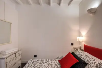 a white bedroom with a bed and a dresser at Campo de' Fiori Stylish White in Rome