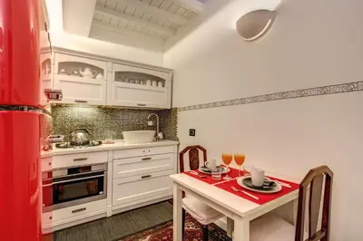 a kitchen with white cabinets and a table with drinks on it at Campo de' Fiori Stylish White in Rome