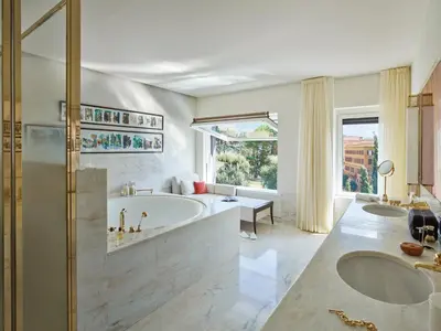 a large bathroom with two sinks and a tub at Hotel Eden - Dorchester Collection in Rome