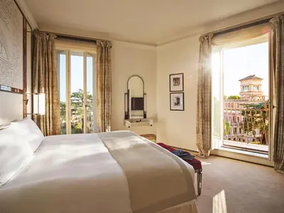 a bedroom with a large bed and a large window at Hotel Eden - Dorchester Collection in Rome