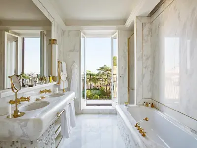 a white bathroom with a tub and a sink at Hotel Eden - Dorchester Collection in Rome