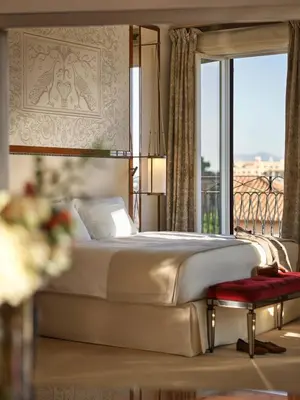 a bedroom with a bed and a large window at Hotel Eden - Dorchester Collection in Rome