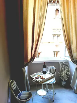 a table and chairs in front of a window at Aleardo Aleardi in Rome