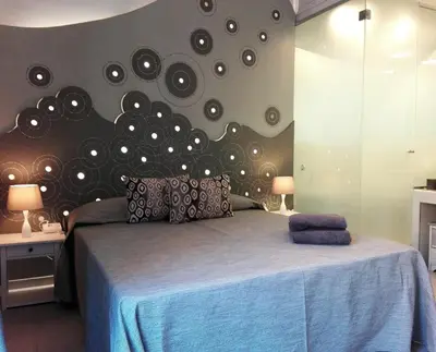 a bedroom with a bed with a wall with many mirrors at Aleardo Aleardi in Rome