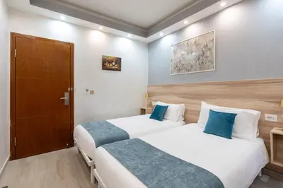 two beds in a hotel room with blue pillows at Leone D'Oro GUESTHOUSE - close to Piazza Vittorio in Rome