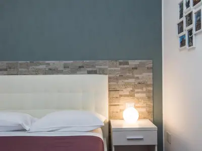 a bedroom with a bed with a lamp on a night stand at Guesthouse Park Pines in Rome