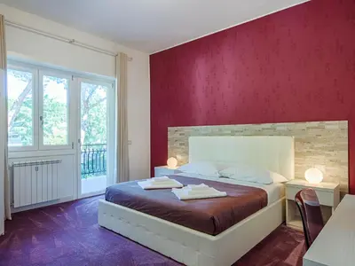 a bedroom with a bed with a red wall at Guesthouse Park Pines in Rome