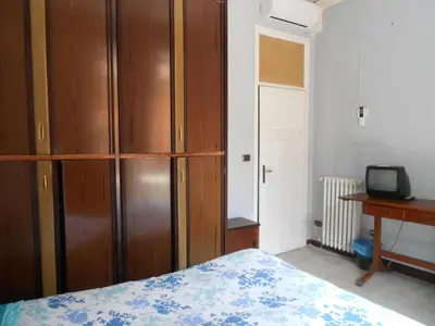 a bedroom with a wooden cabinet and a bed at Casa di Roma in Rome