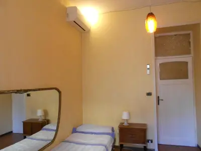 a bedroom with two beds and a mirror at Casa di Roma in Rome