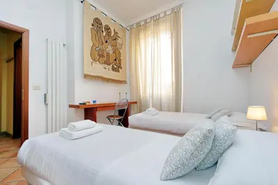 a hotel room with two beds and a desk at Romalibera in Rome
