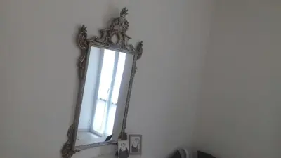 a mirror hanging on a wall with a window at Apartment Ostiense Piramide Station in Rome