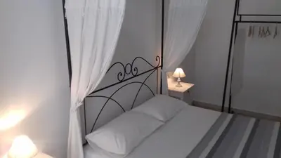 a bedroom with a white bed with a metal headboard at Apartment Ostiense Piramide Station in Rome