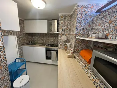 a kitchen with white cabinets and an orange stool at Foro Romano Apartments A in Rome