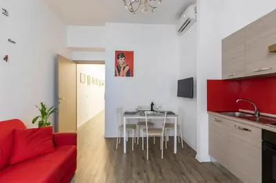 a living room with a red couch and a table at Cornelia House in Rome