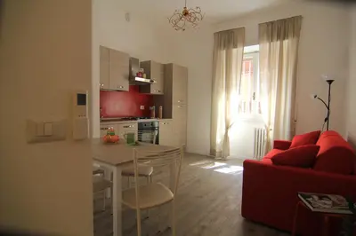 a living room with a red couch and a table at Cornelia House in Rome