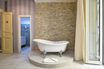 a bath tub in a bathroom with a brick wall at Vatican Nausicaa in Rome