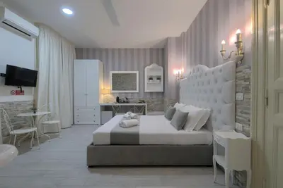 a bedroom with a large white bed and a kitchen at Vatican Nausicaa in Rome