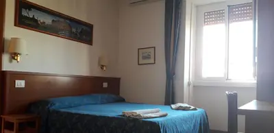 a bedroom with a bed with blue sheets and a window at Filiberto Apartment in Rome