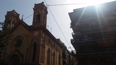 a church with a clock tower in front of a building at Filiberto Apartment in Rome