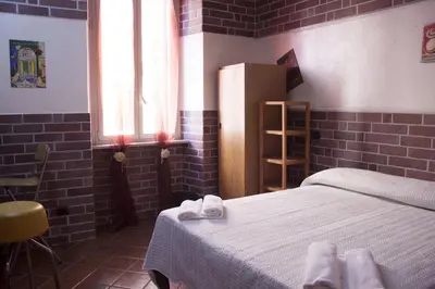 a bedroom with a bed with white sheets and a window at Hotel Agorà in Rome