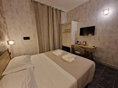 a hotel room with a white bed and a desk at Hotel Agorà in Rome