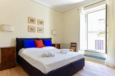 a bedroom with a bed with blue and red pillows at Bright and Comfy 3 bedroom apt in Monti in Rome