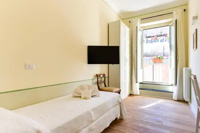 a white bedroom with a bed and a window at Bright and Comfy 3 bedroom apt in Monti in Rome