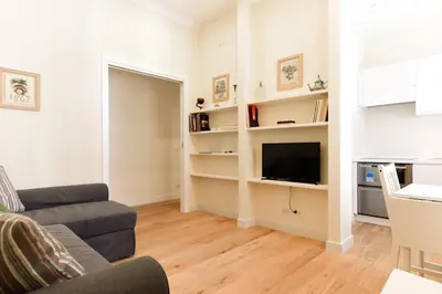 a living room with a couch and a tv at Bright and Comfy 3 bedroom apt in Monti in Rome