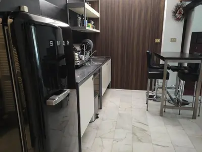 a kitchen with a black refrigerator and a table at Your secret place in Rome in Rome