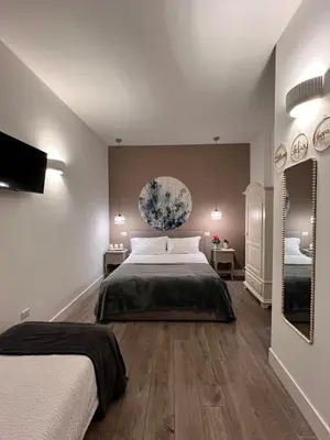 a bedroom with two beds and a mirror at Antinori Vatican Suite in Rome