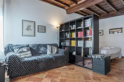 a living room with a couch and a book shelf at Black White - FromHometoRome in Rome
