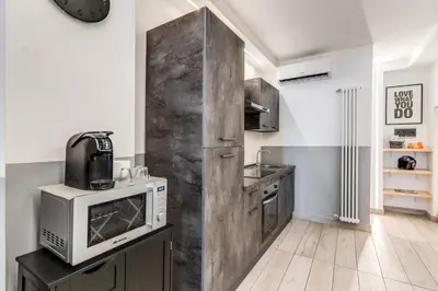 a kitchen with a large wooden partition with a microwave at Costaguti 36 Apartment in Rome