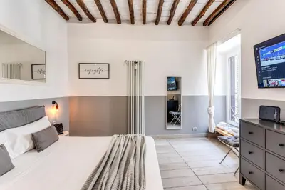 a bedroom with a large bed and a tv at Costaguti 36 Apartment in Rome