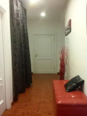 a living room with a door and a red leather couch at Magic Stefy's Rooms in Rome