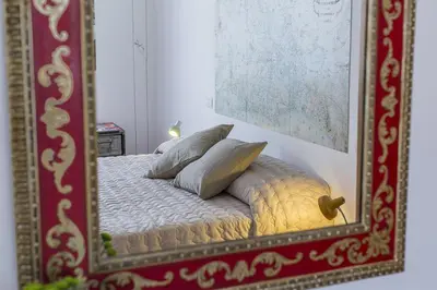 a mirror reflection of a bed with pillows on it at Casa Vacanza 