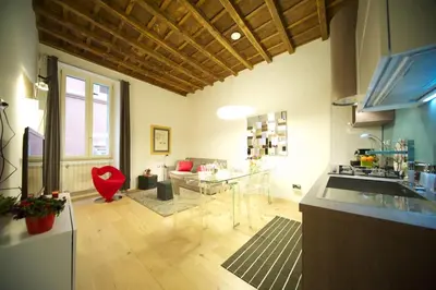 a kitchen with a glass table and a living room at Fico Blu in Rome