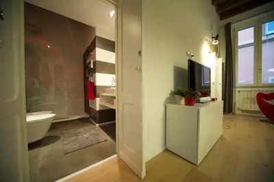 a bathroom with a tub and a toilet and a television at Fico Blu in Rome