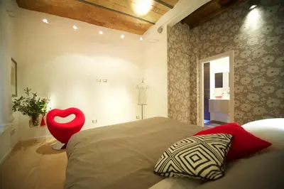 a bedroom with a bed and a red chair at Fico Blu in Rome