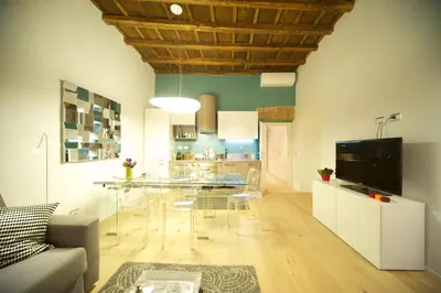 a living room with a glass table and a kitchen at Fico Blu in Rome