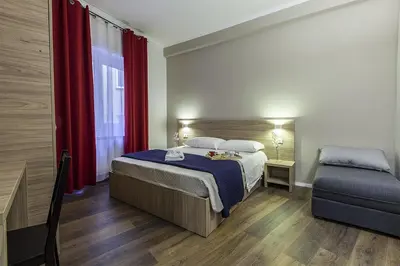 a bedroom with a bed and a red curtain at La Palma in Rome