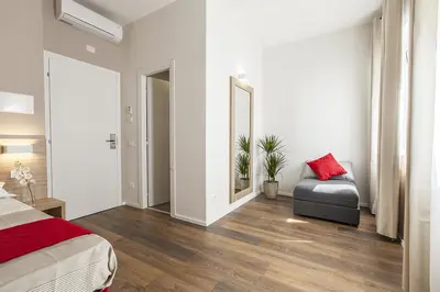 a bedroom with a bed and a chair and a mirror at La Palma in Rome