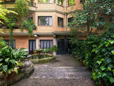 a building with a courtyard with a fountain in front of it at Vatican Holiday Apartment 307 in Rome