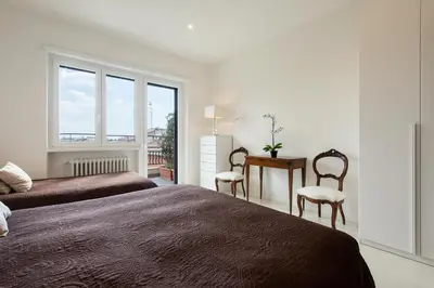 a bedroom with two beds and a desk and a window at Vatican Holiday Apartment 307 in Rome