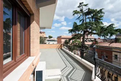 a balcony with a view of a tree and buildings at Vatican Holiday Apartment 307 in Rome