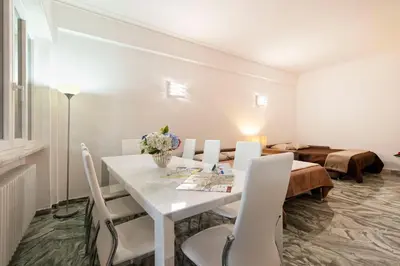 a white dining room with a white table and chairs at Vatican Holiday Apartment 307 in Rome