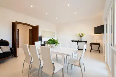 a dining room with a white table and chairs at Vatican Holiday Apartment 307 in Rome