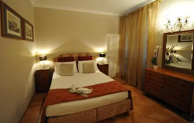 a bedroom with a bed and a dresser and a mirror at Angel Spagna Suite in Rome